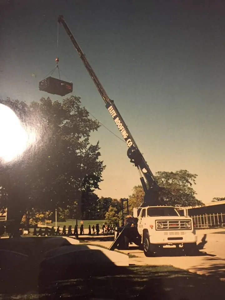 Elite Roofing and Sheet Metal crane hoisting equipment onto a commercial rooftop