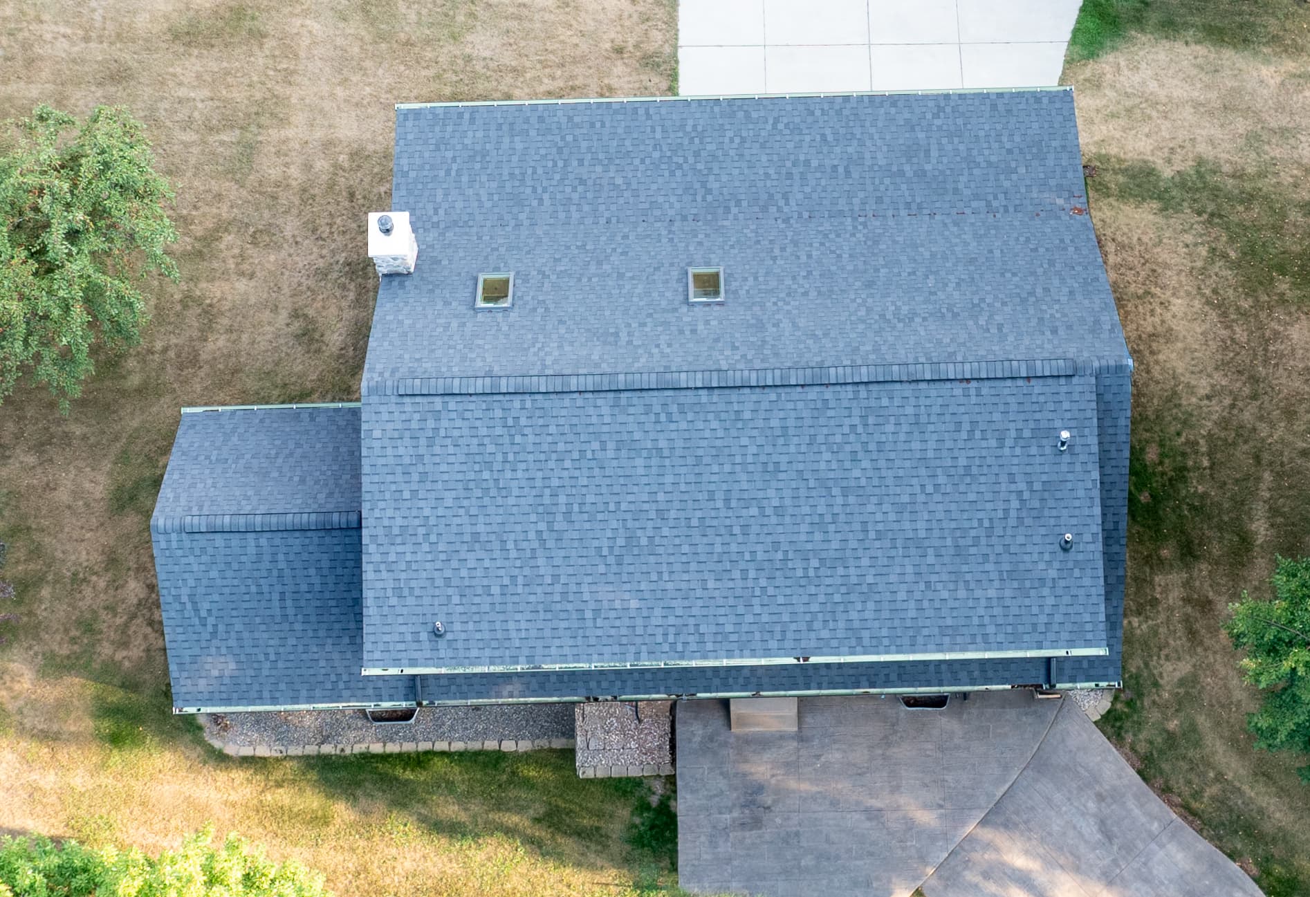 Overhead view of a completed steep roof showing skylights, ridge cap and clean eave lines